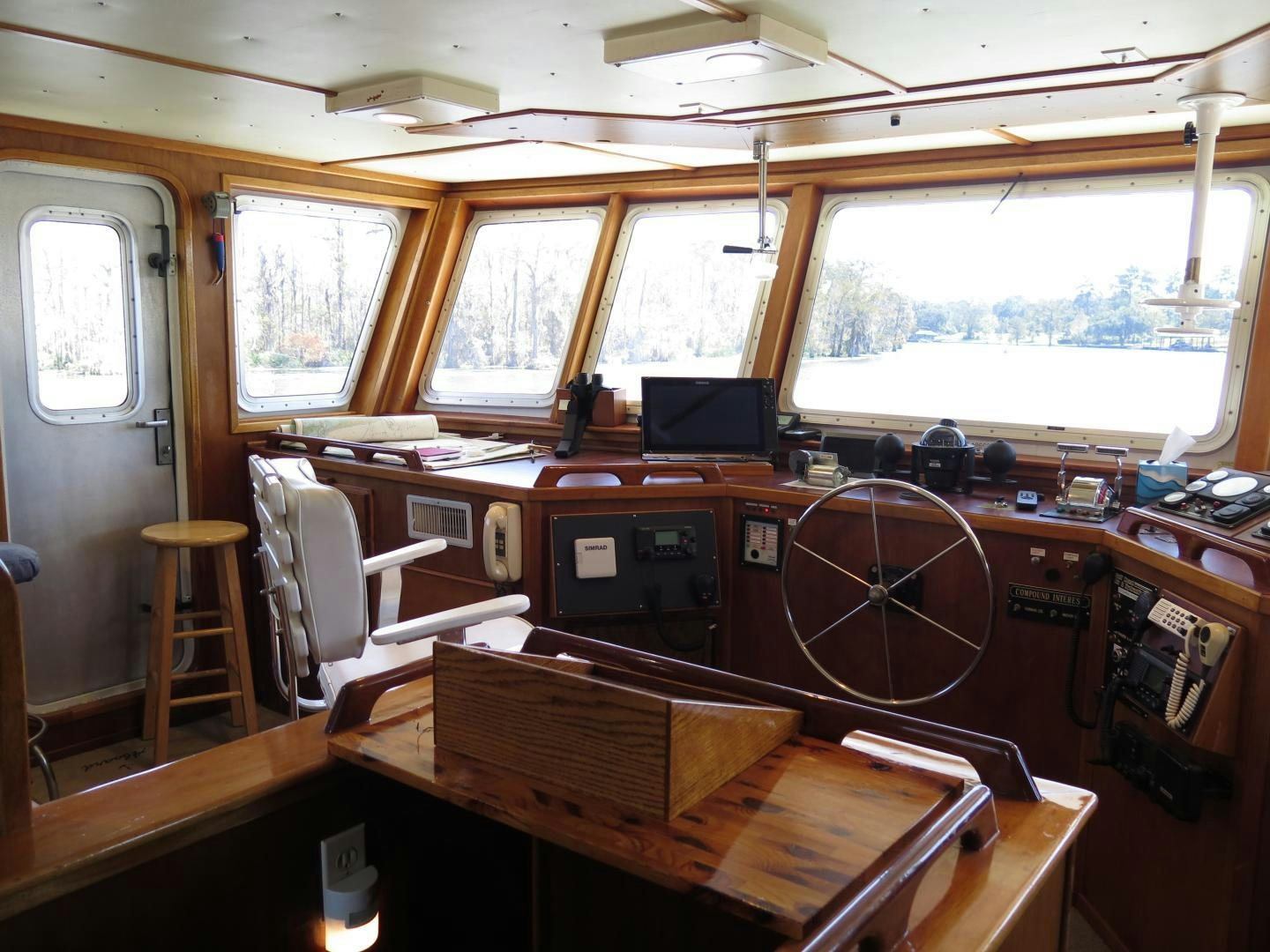 a wooden boat with a large wooden steering wheel aboard WANDERER Yacht for Sale