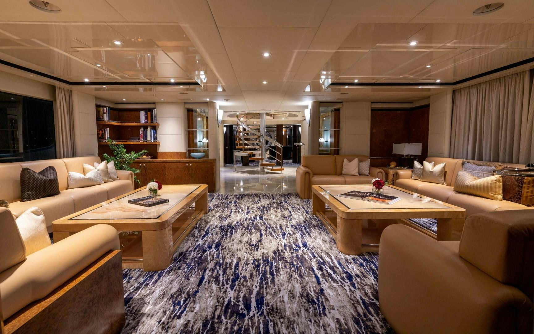 a large living room with a blue rug aboard 4 ROSES Yacht for Sale