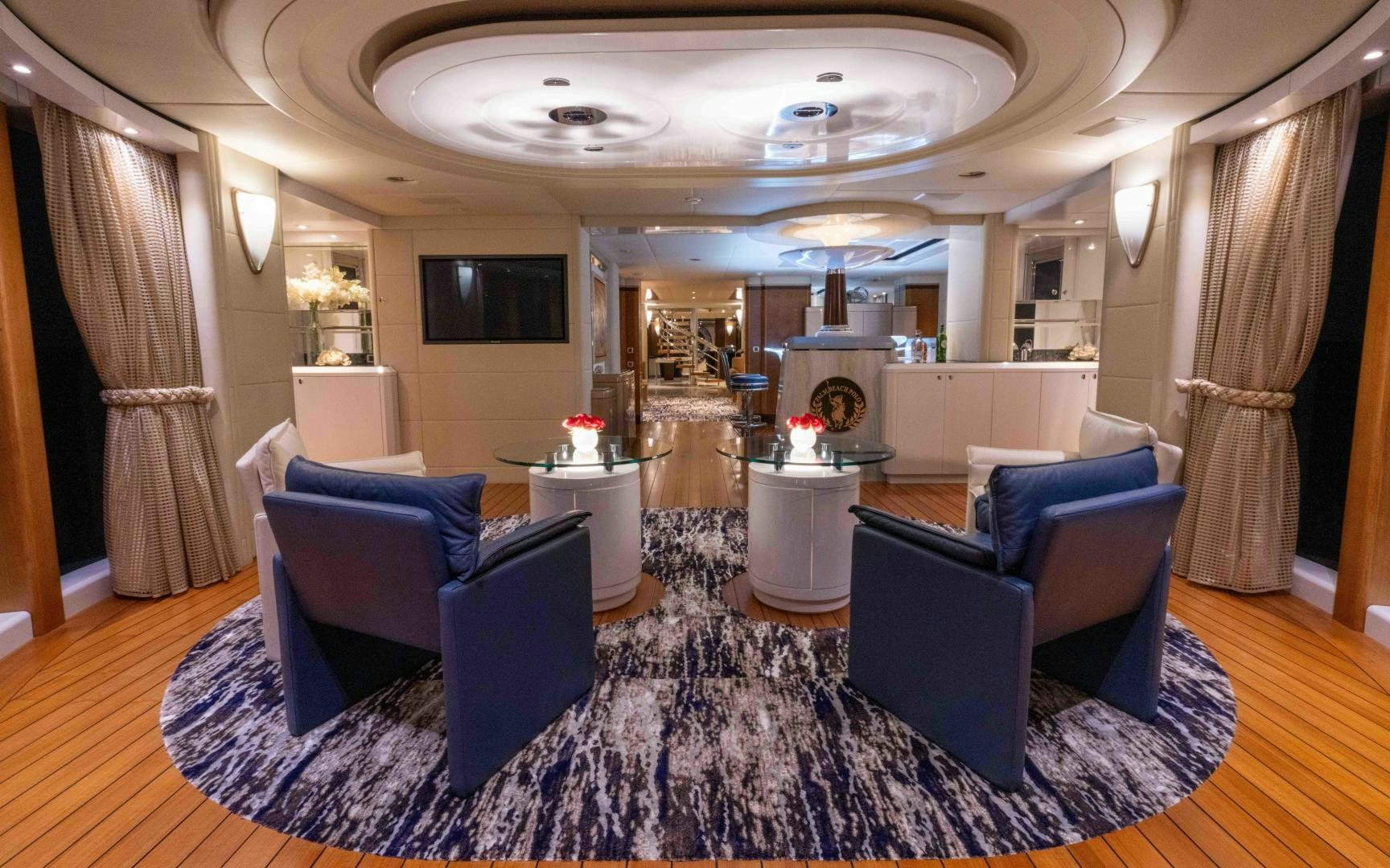 a large living room with blue chairs aboard 4 ROSES Yacht for Sale
