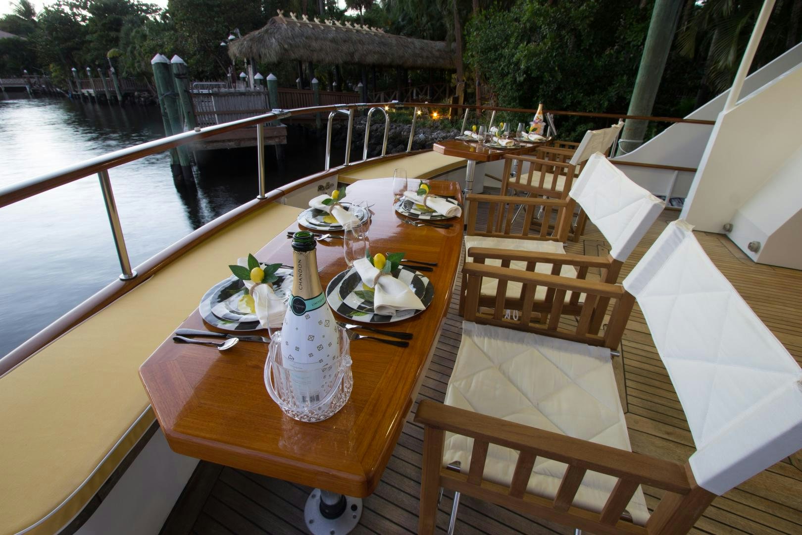 a table with plates and glasses on it next to a body of water aboard SEAEO Yacht for Sale