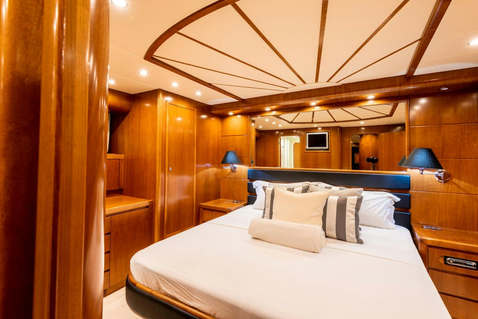 a bed with a white sheet and pillows in a room with wood walls aboard SEA FALCON Yacht for Sale
