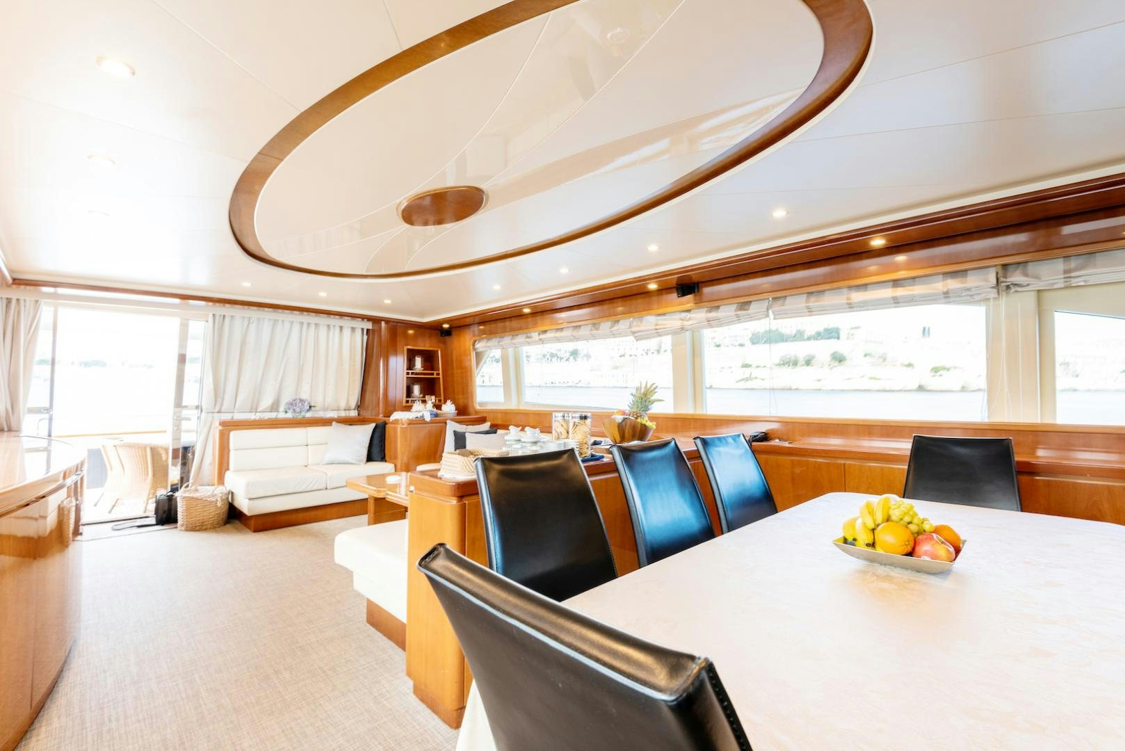 a large room with a table and chairs and a large window aboard SEA FALCON Yacht for Sale