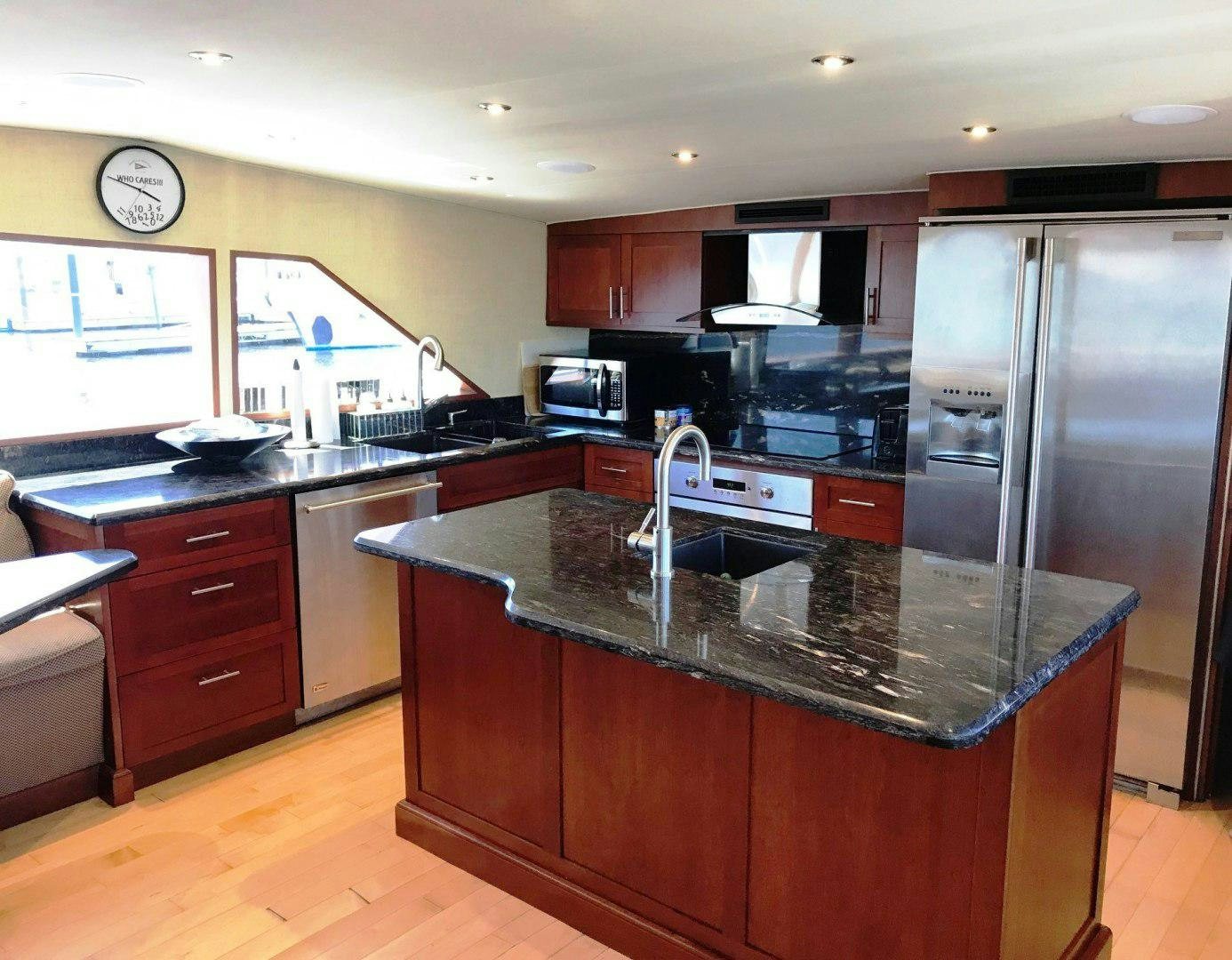 a kitchen with a stainless steel refrigerator aboard CORDINA Yacht for Sale