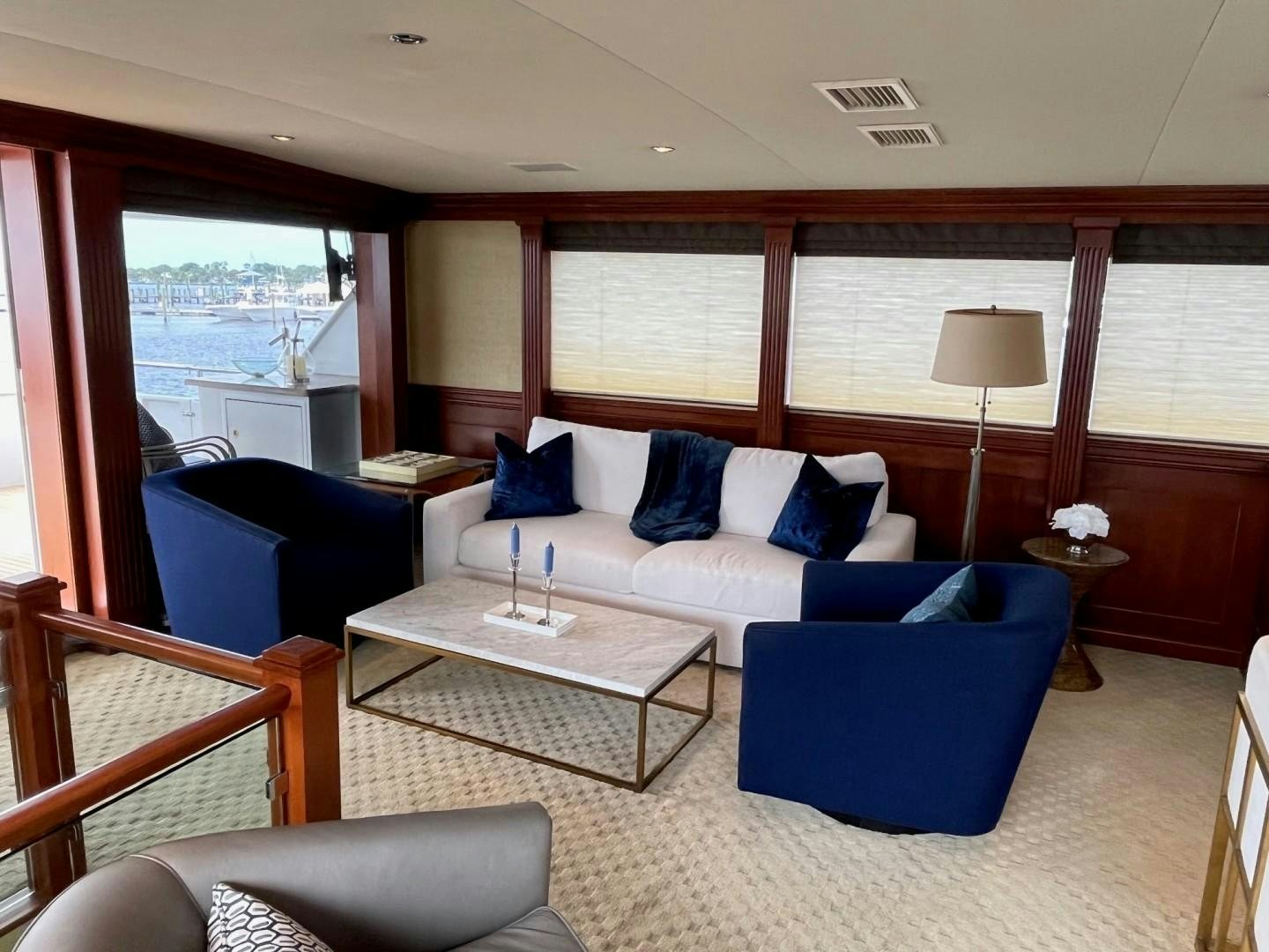 a living room with a blue couch and a table aboard CORDINA Yacht for Sale