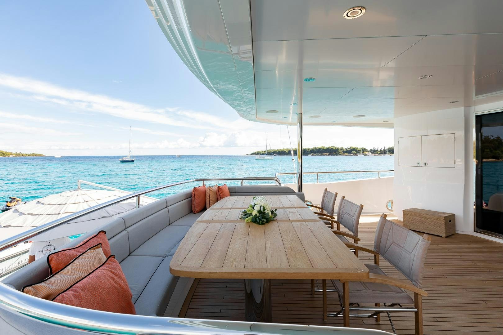 a table and chairs on a deck overlooking a body of water aboard SEDATIVE Yacht for Sale