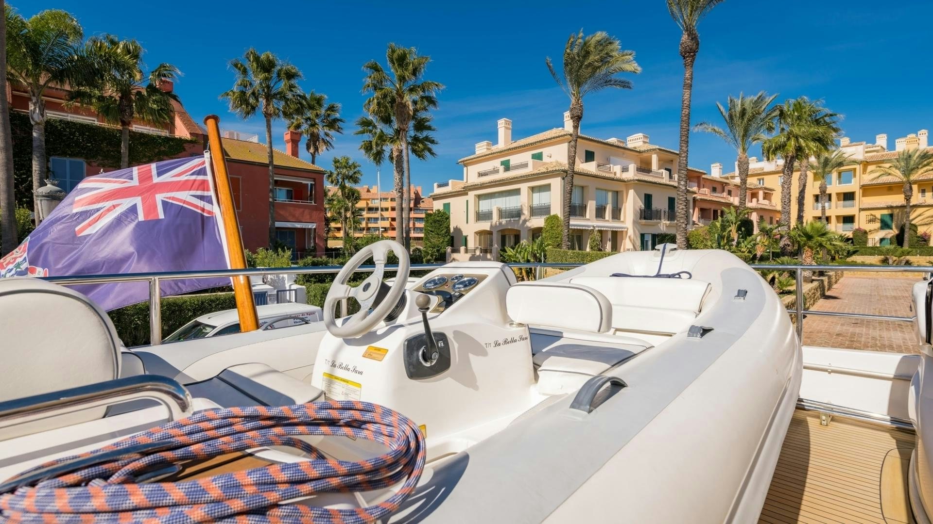 a white convertible car with a pink umbrella on a sunny day aboard LA BELLA SARA III Yacht for Sale