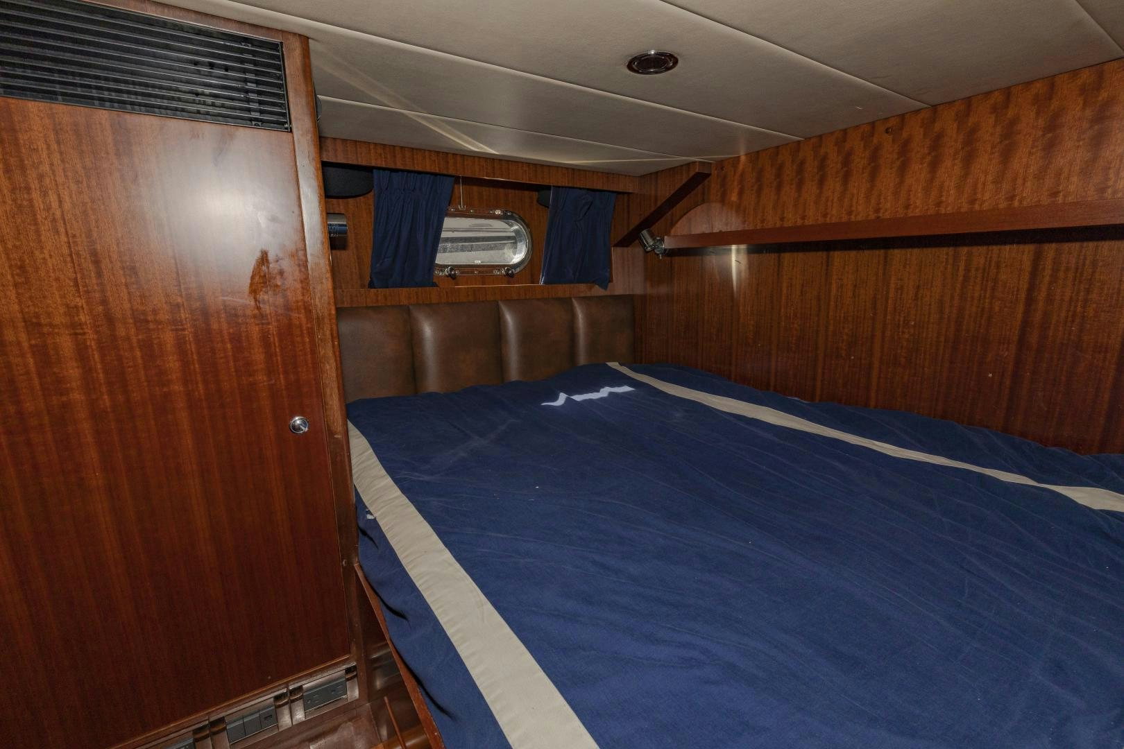 a room with a bed and a wood closet aboard VIAGGIO Yacht for Sale