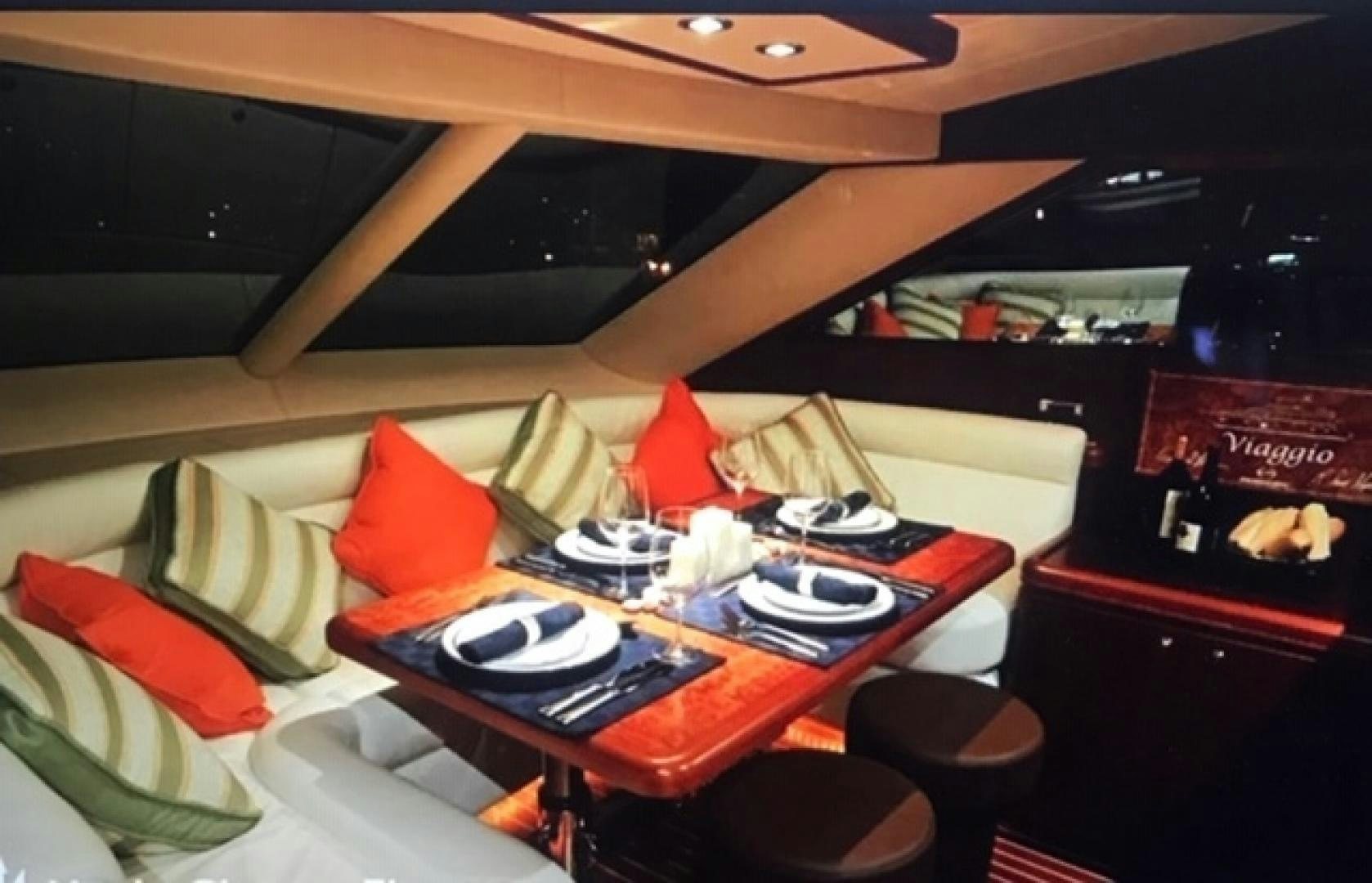 a bed with a table and chairs aboard VIAGGIO Yacht for Sale