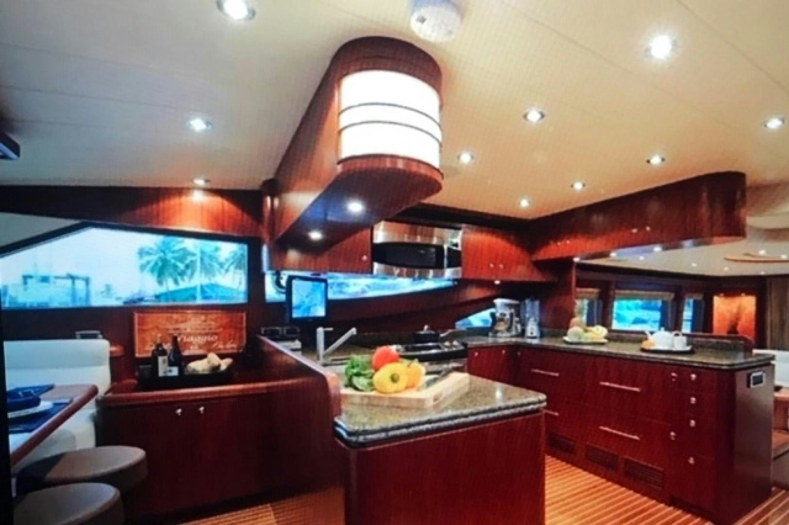 a kitchen with red cabinets and a large island with a lamp on top aboard VIAGGIO Yacht for Sale