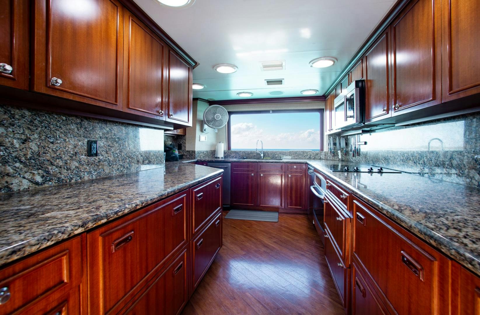 a large kitchen with wooden cabinets aboard THREE KINGS Yacht for Sale