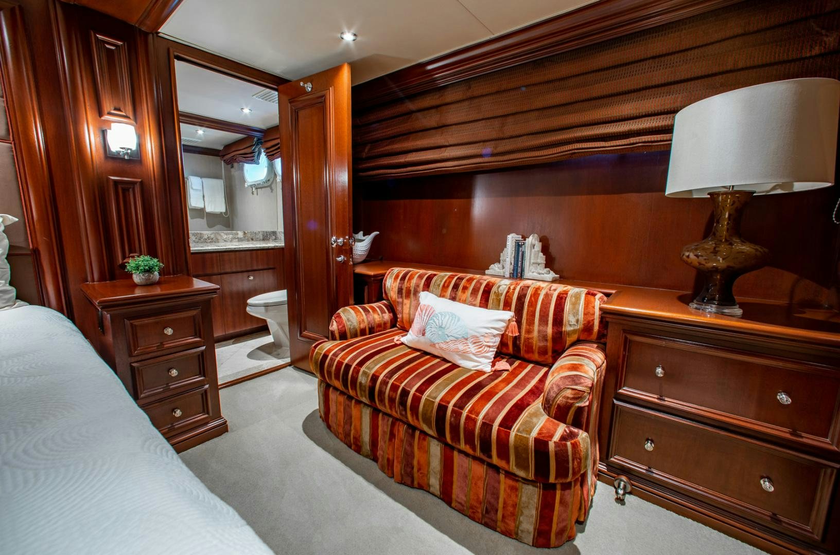 a bedroom with a bed and a chair aboard THREE KINGS Yacht for Sale