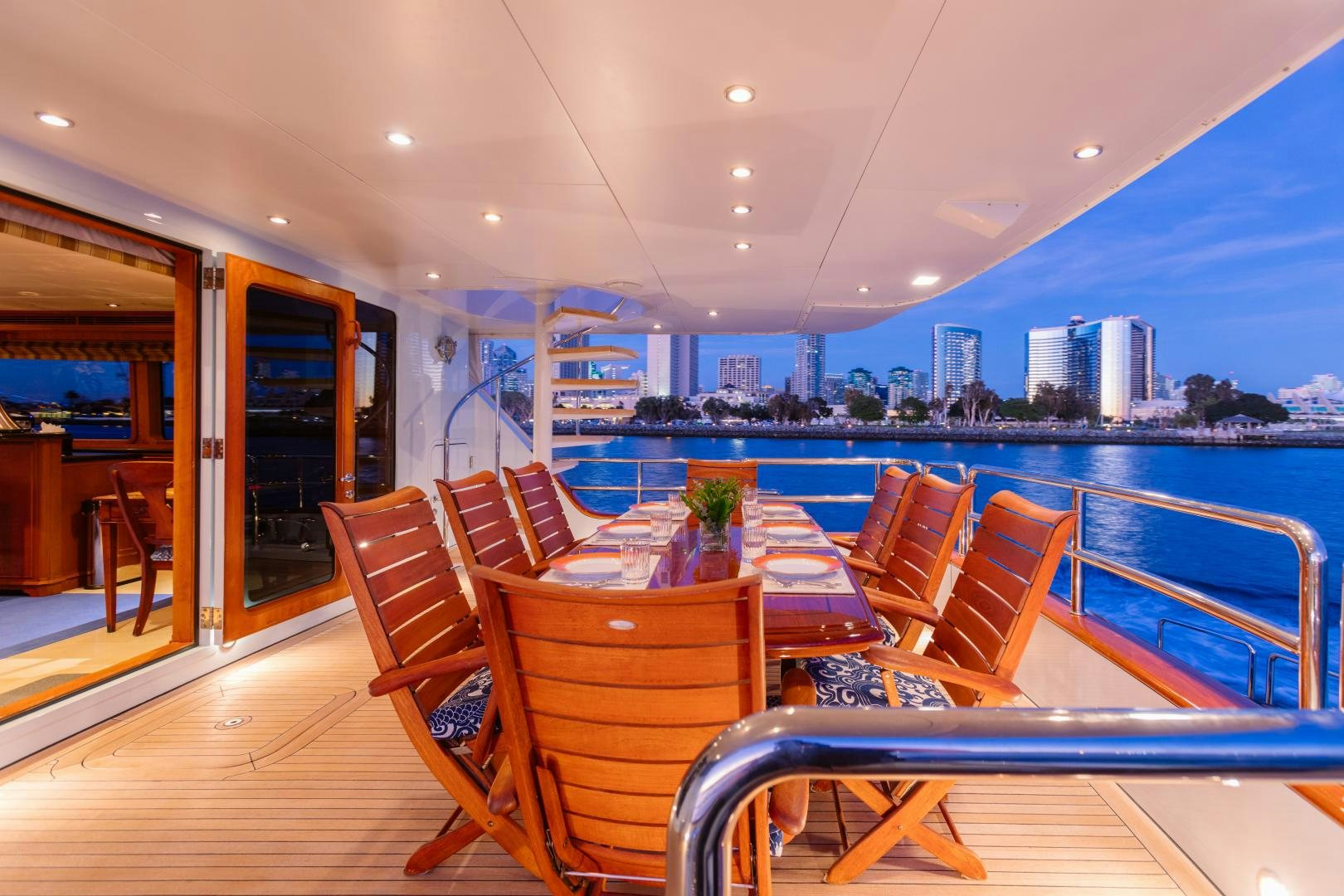 a room with a table and chairs and a view of a city aboard APHRODITE Yacht for Sale