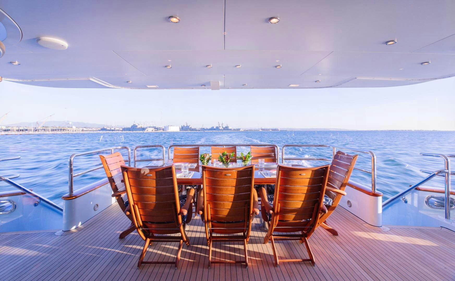 a table set for a meal on a deck overlooking a large body of water aboard APHRODITE Yacht for Sale