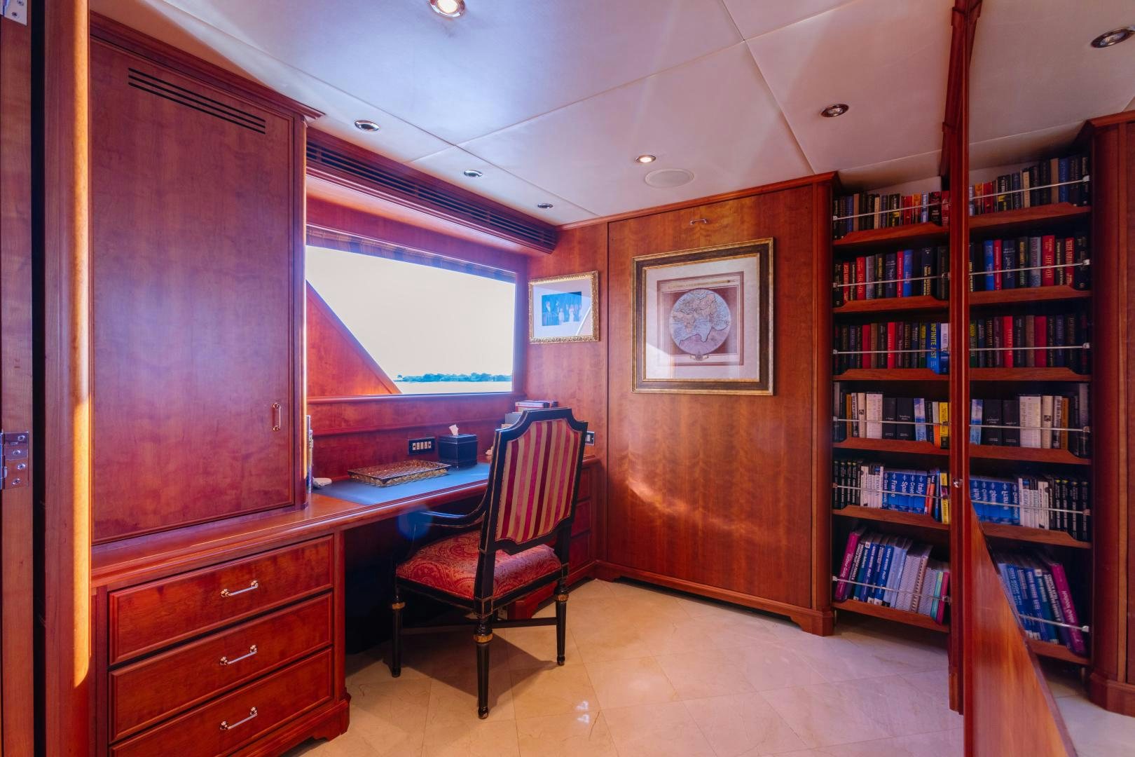 a room with a desk and a chair and a bookcase aboard APHRODITE Yacht for Sale