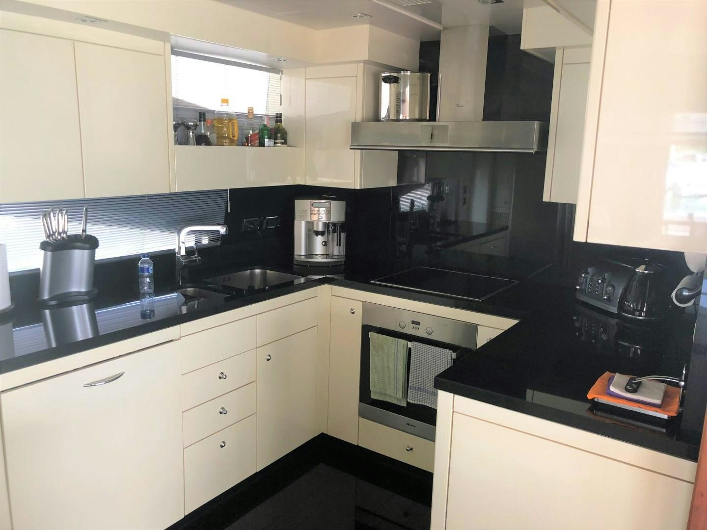 a kitchen with white cabinets aboard SYDNEY Yacht for Sale