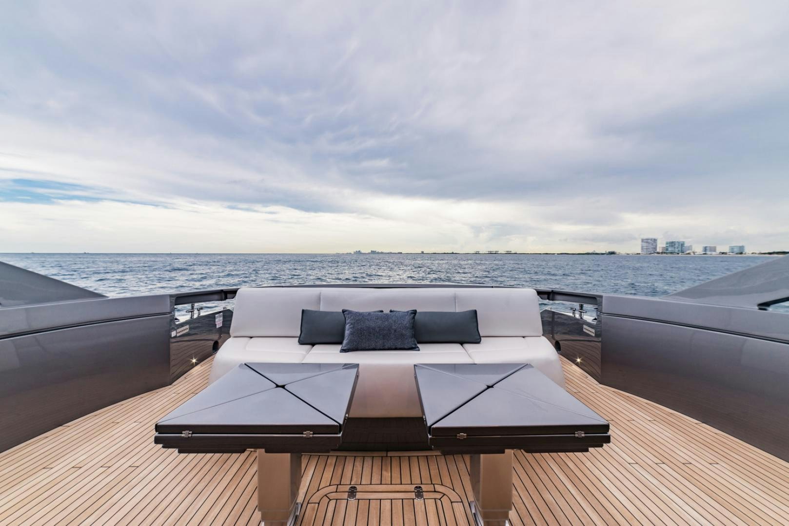a large white couch on a deck overlooking a large body of water aboard BAD DADDY Yacht for Sale