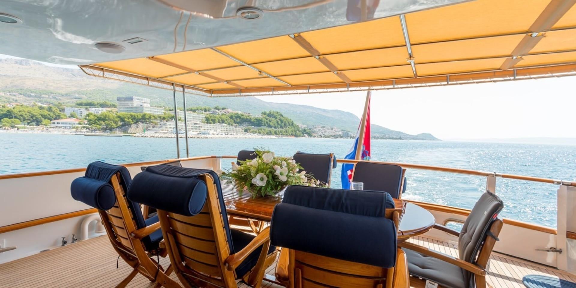a boat with chairs and a table on the deck aboard ADRIATIC ESCAPE Yacht for Sale