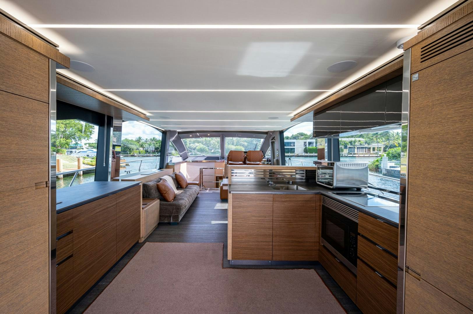 a room with a large window and a kitchen with a view of the city aboard LEBRADA Yacht for Sale