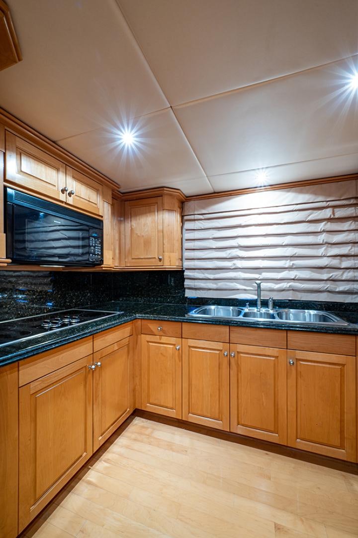 a kitchen with wooden cabinets aboard CANDY WORLD Yacht for Sale