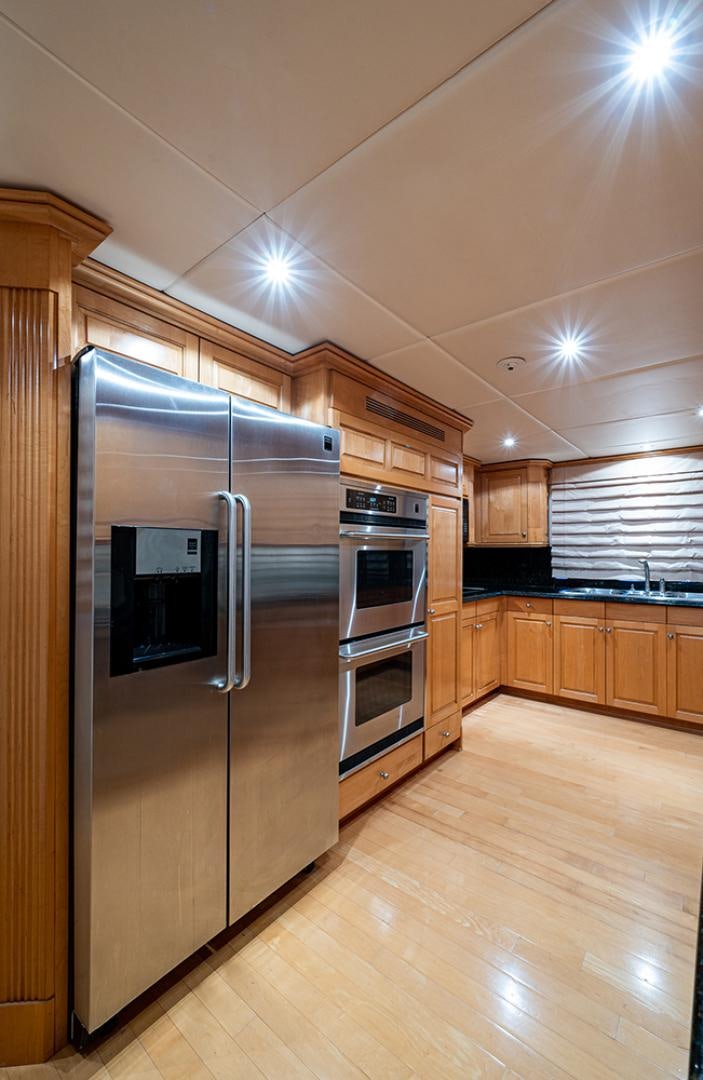 a kitchen with wooden cabinets aboard CANDY WORLD Yacht for Sale