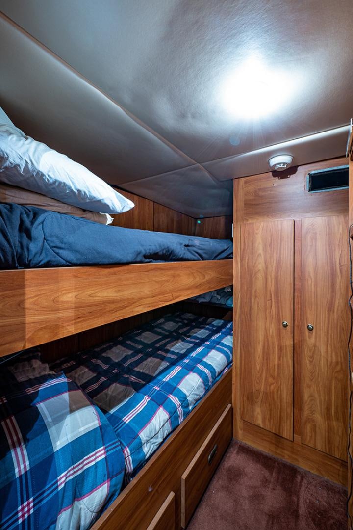 a bed with a blue comforter aboard CANDY WORLD Yacht for Sale