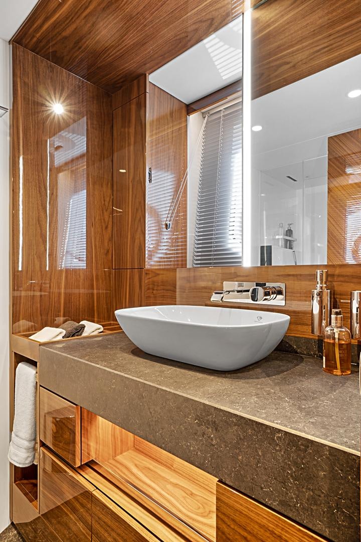 a bathroom with a sink and a large mirror aboard YOUNG HEARTS Yacht for Sale