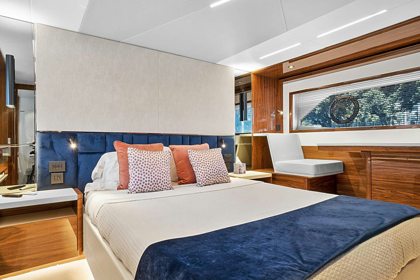 a bed with pillows and a chair aboard YOUNG HEARTS Yacht for Sale