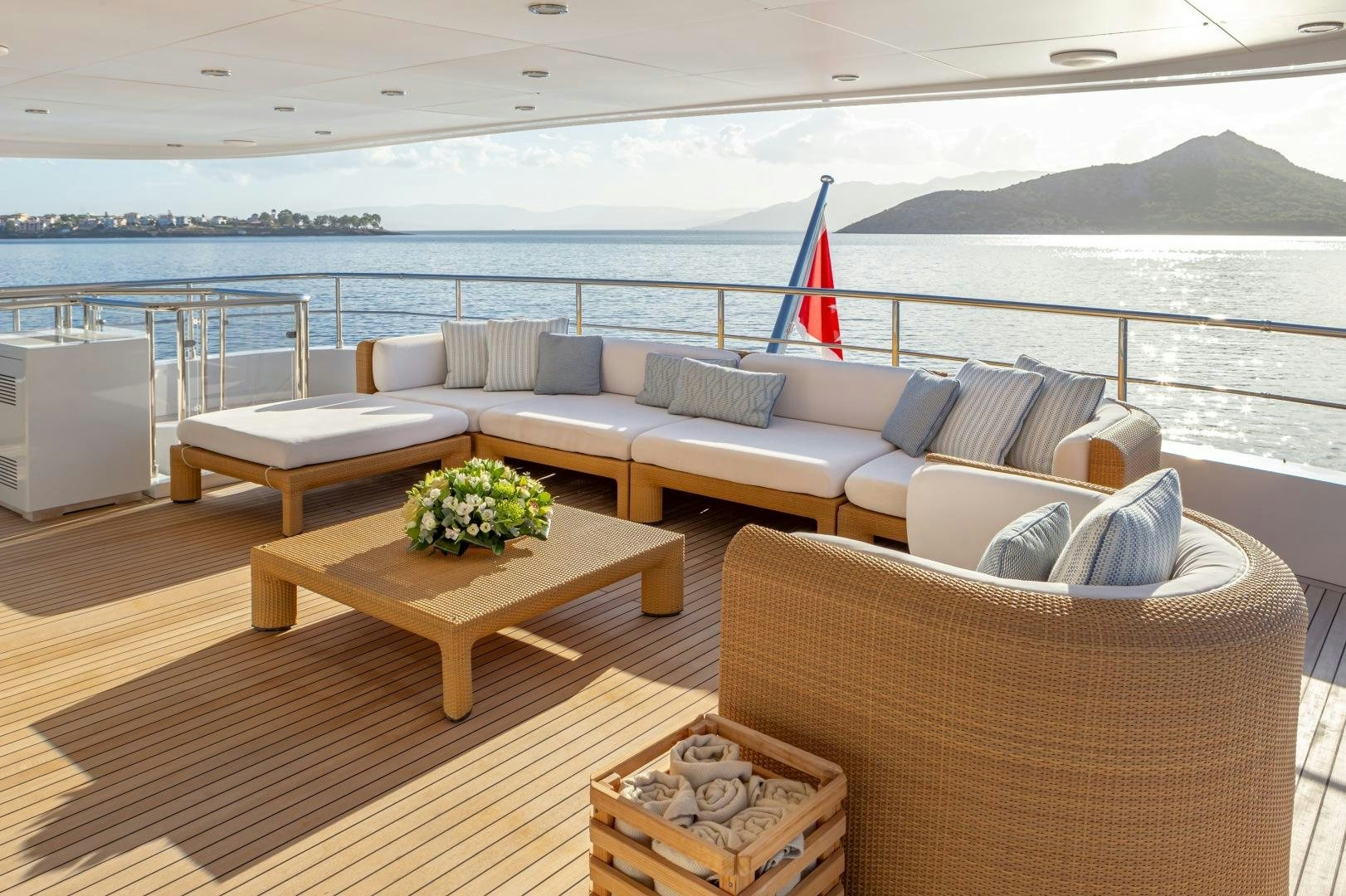 a living room with a large body of water and a large boat in the background aboard ZALIV III Yacht for Sale