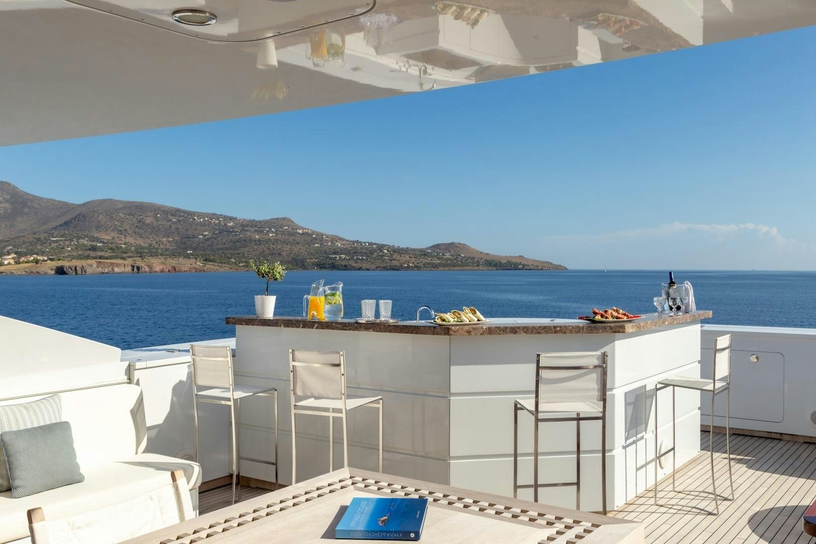 a large white table with chairs on it next to a body of water aboard ZALIV III Yacht for Sale