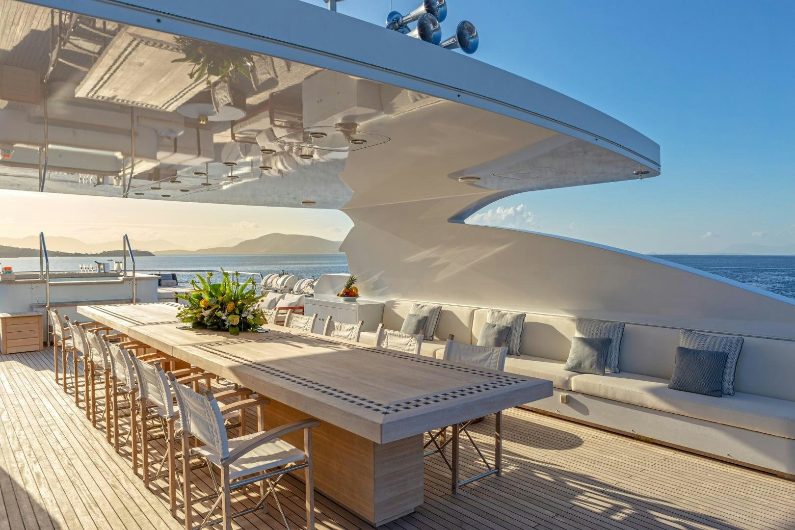 a deck with a pool and a deck with chairs and a table aboard ZALIV III Yacht for Sale