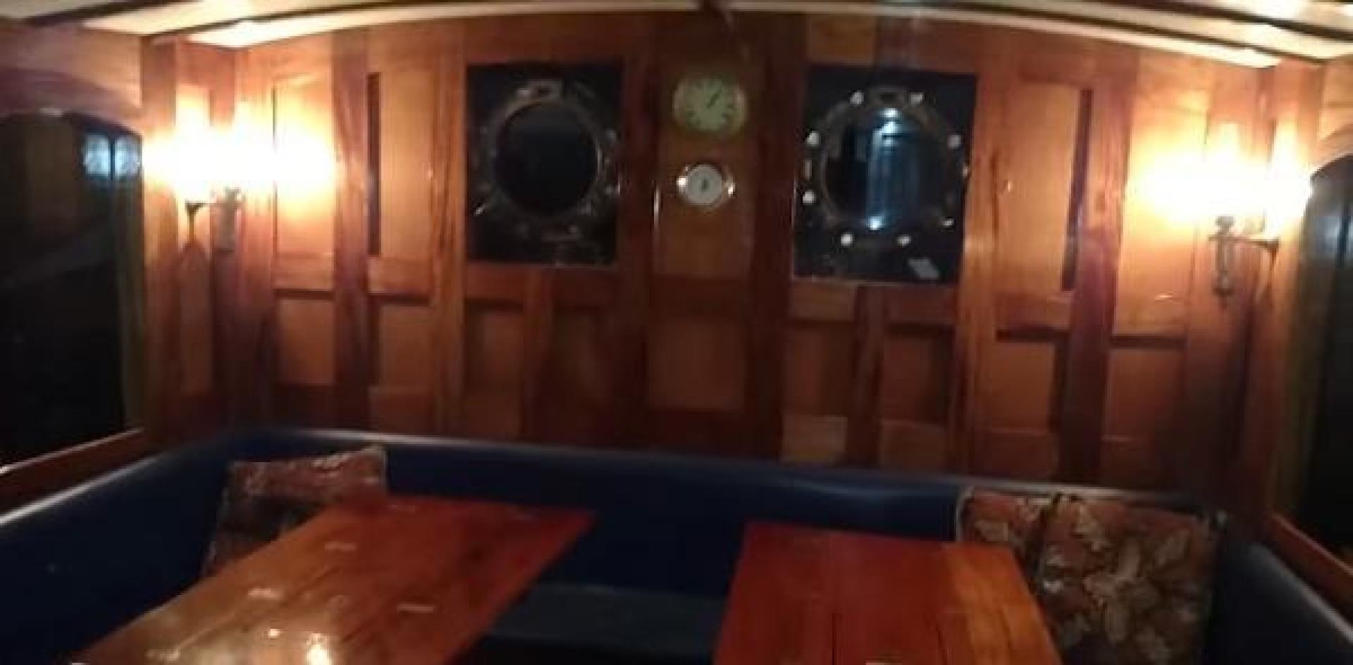 a room with a table and a couch aboard WANDERBIRD Yacht for Sale