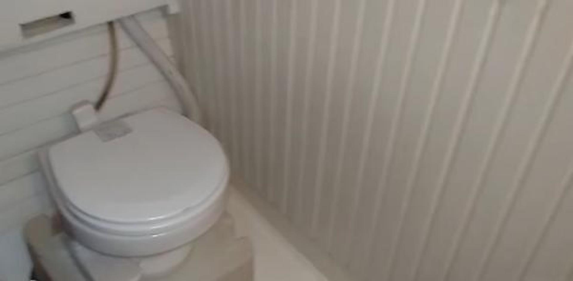 a toilet with a wooden handle aboard WANDERBIRD Yacht for Sale