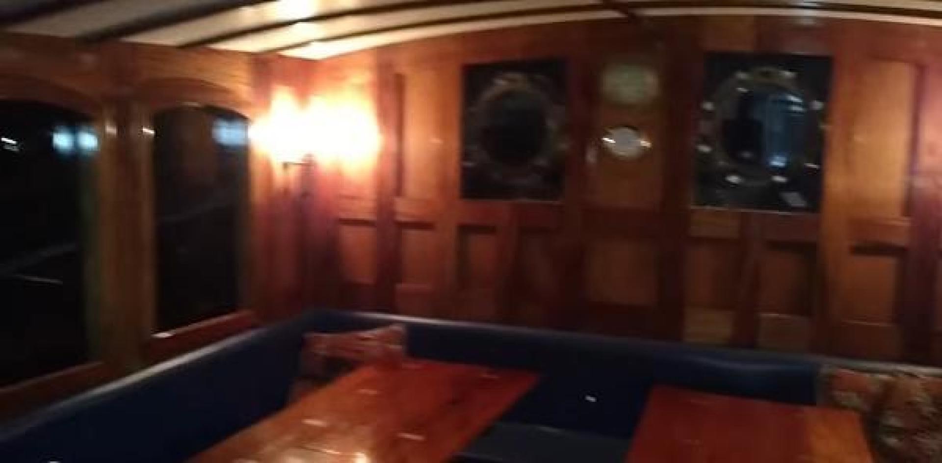 a room with a table and a television on the wall aboard WANDERBIRD Yacht for Sale