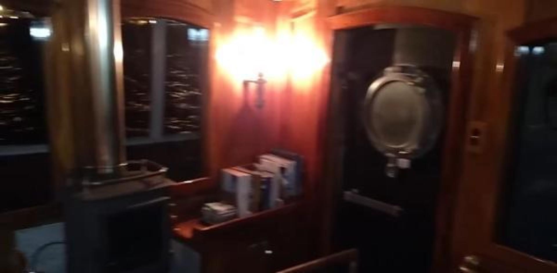 a room with a lamp and a wood table aboard WANDERBIRD Yacht for Sale