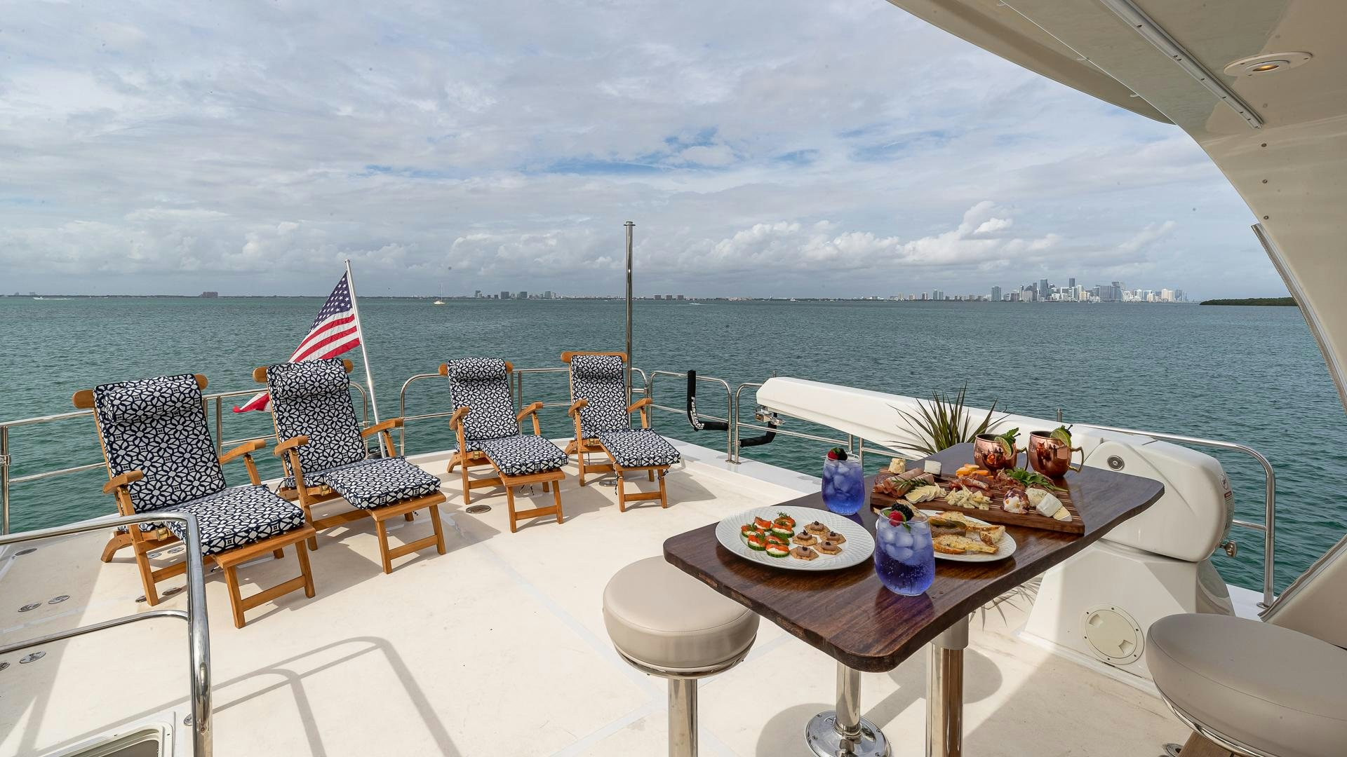 a table with food on it on a balcony overlooking a body of water aboard SAFARI Yacht for Sale