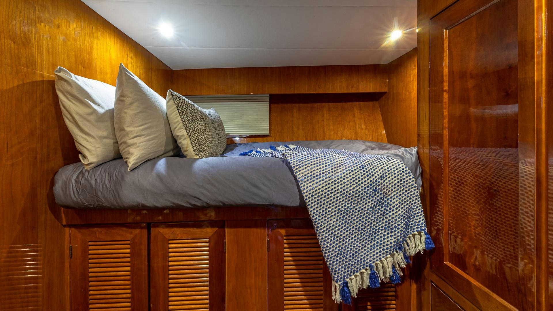 a bed with a blue and white comforter and pillows aboard SAFARI Yacht for Sale