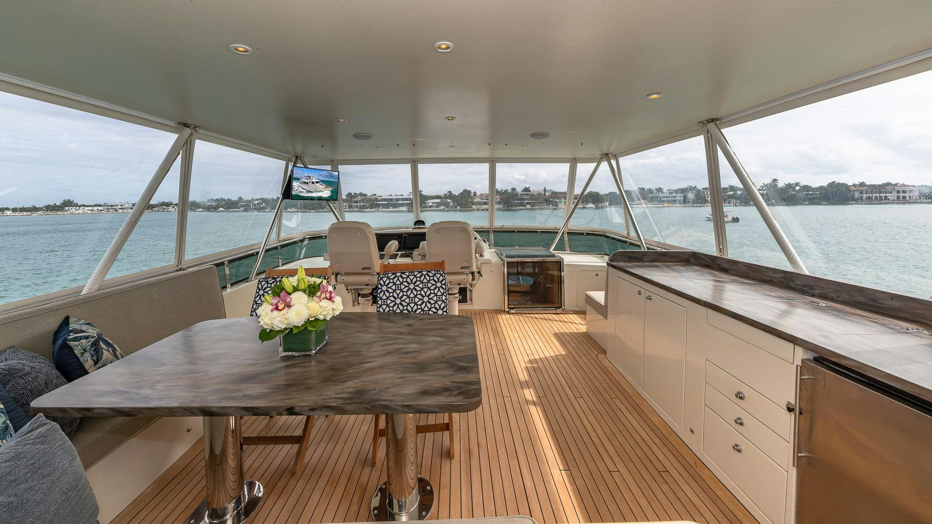 a large open space with a large window and a wood table with chairs and a large body of aboard SAFARI Yacht for Sale