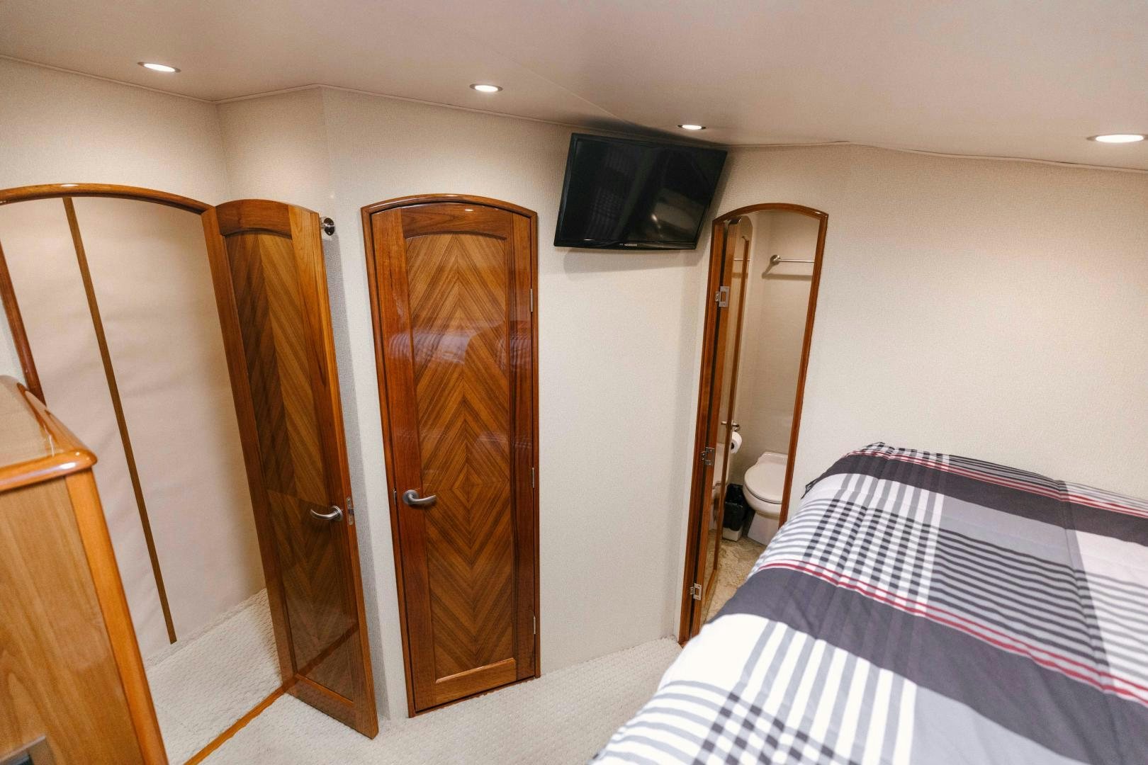 a bedroom with a bed and a television aboard SALTY K Yacht for Sale