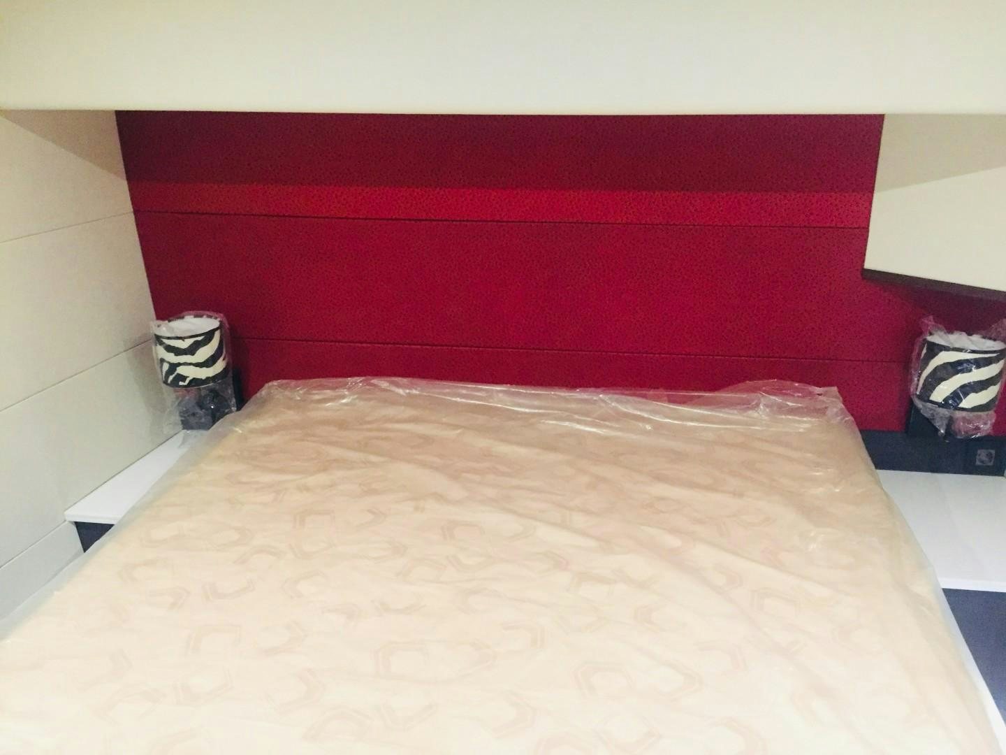 a bed with a red wall aboard SKYE Yacht for Sale