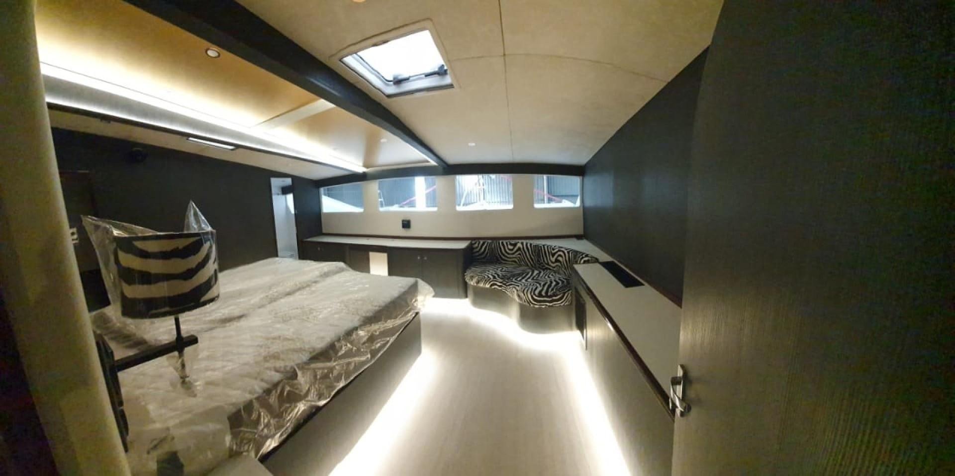 a room with a bed and a chair aboard SKYE Yacht for Sale