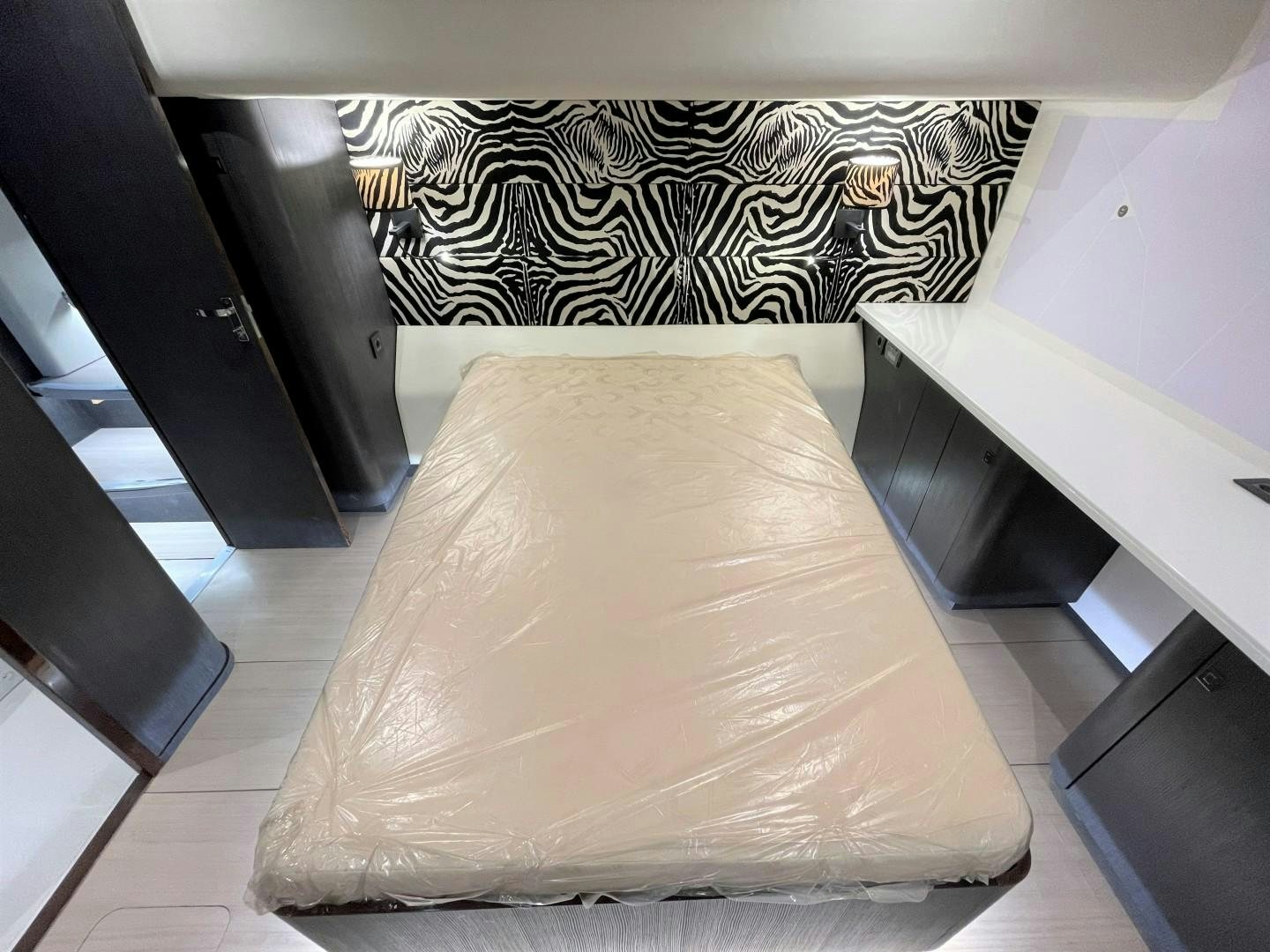 a bed with a black and white striped blanket aboard SKYE Yacht for Sale