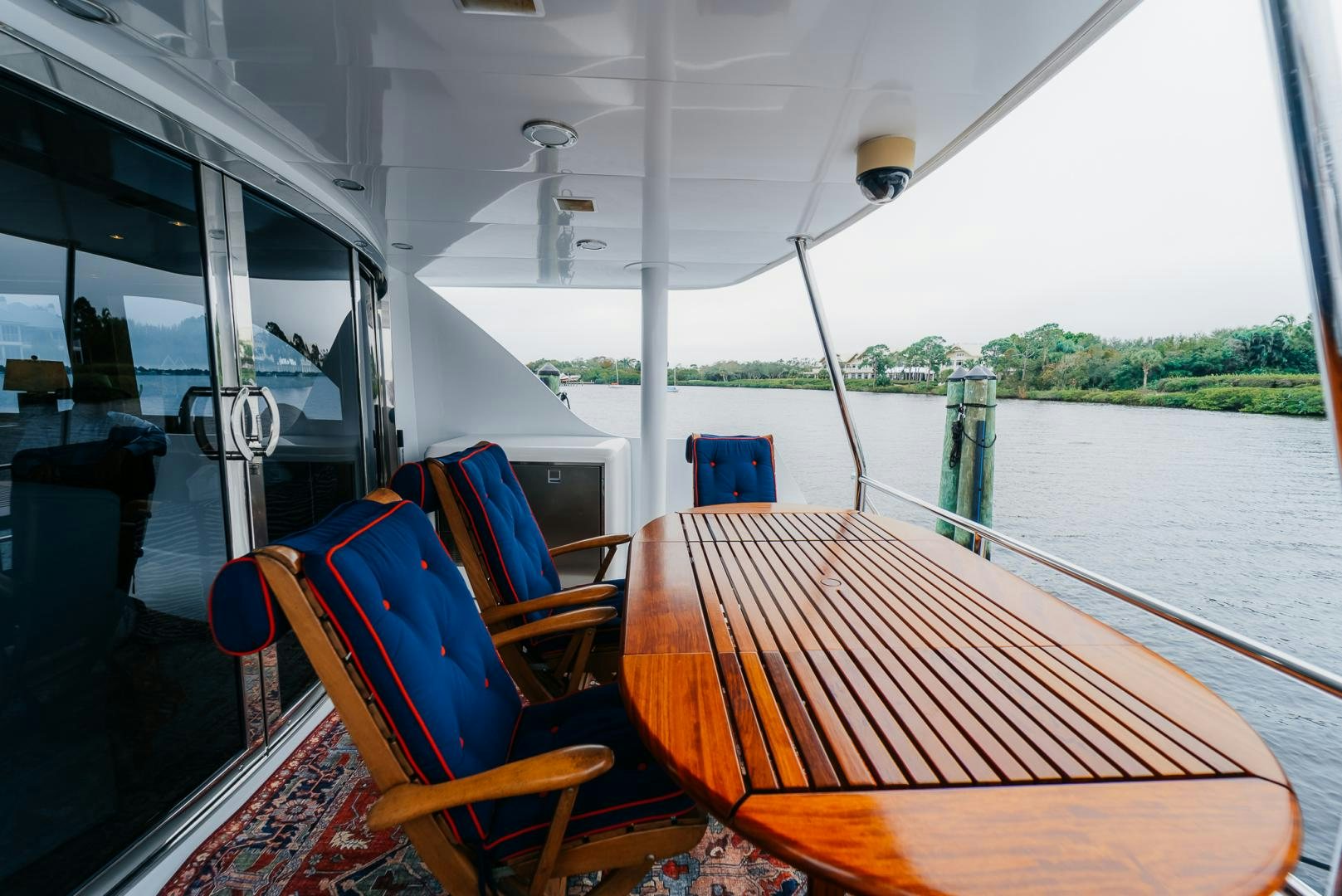 a boat with a wood table and chairs on the deck aboard Haggis XV Yacht for Sale