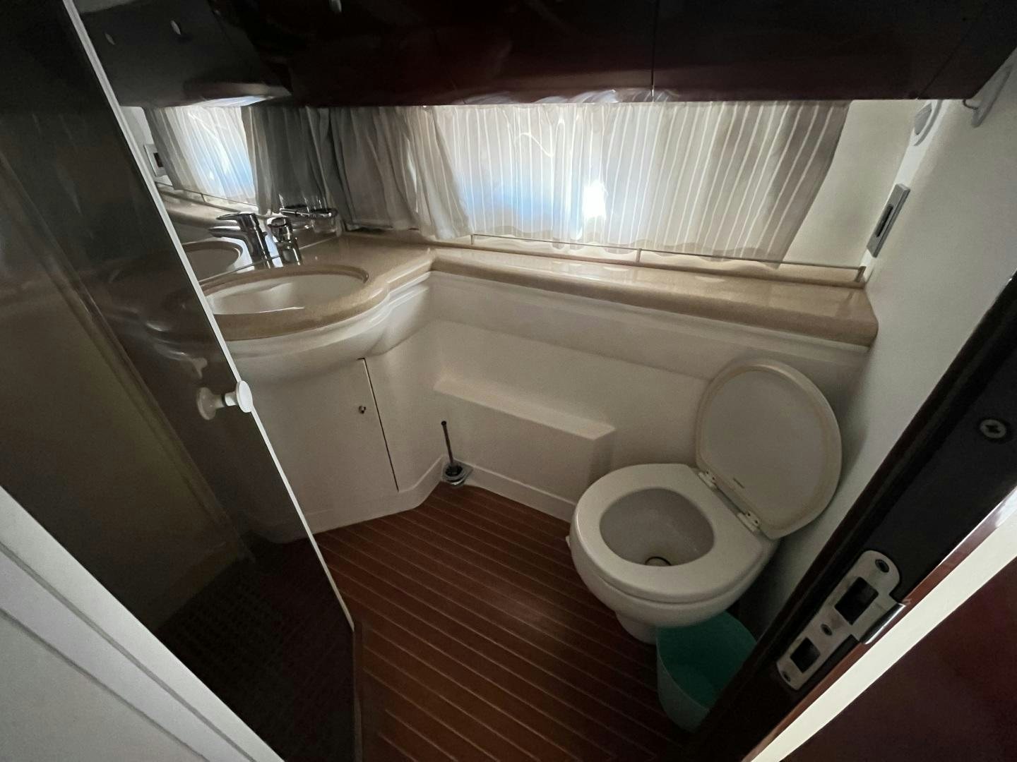 a bathroom with a toilet sink and a window aboard SELAH WAY Yacht for Sale
