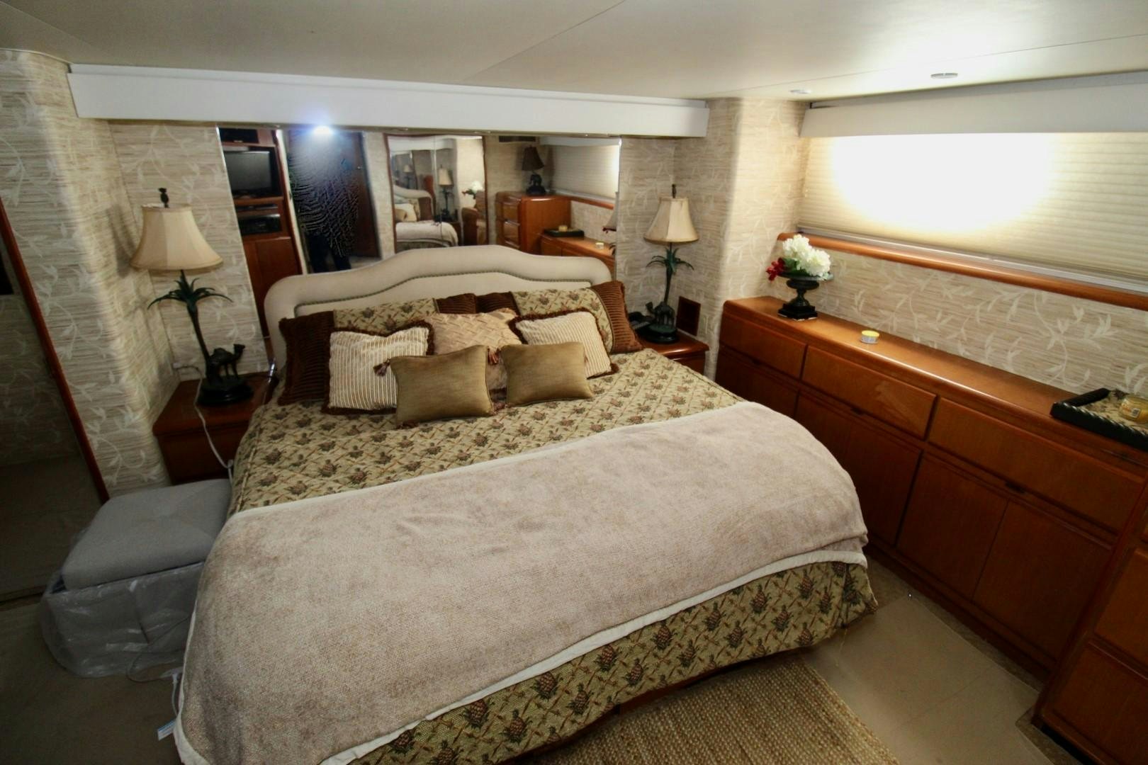a bedroom with a bed and a chair aboard BAD TO THE BONE Yacht for Sale