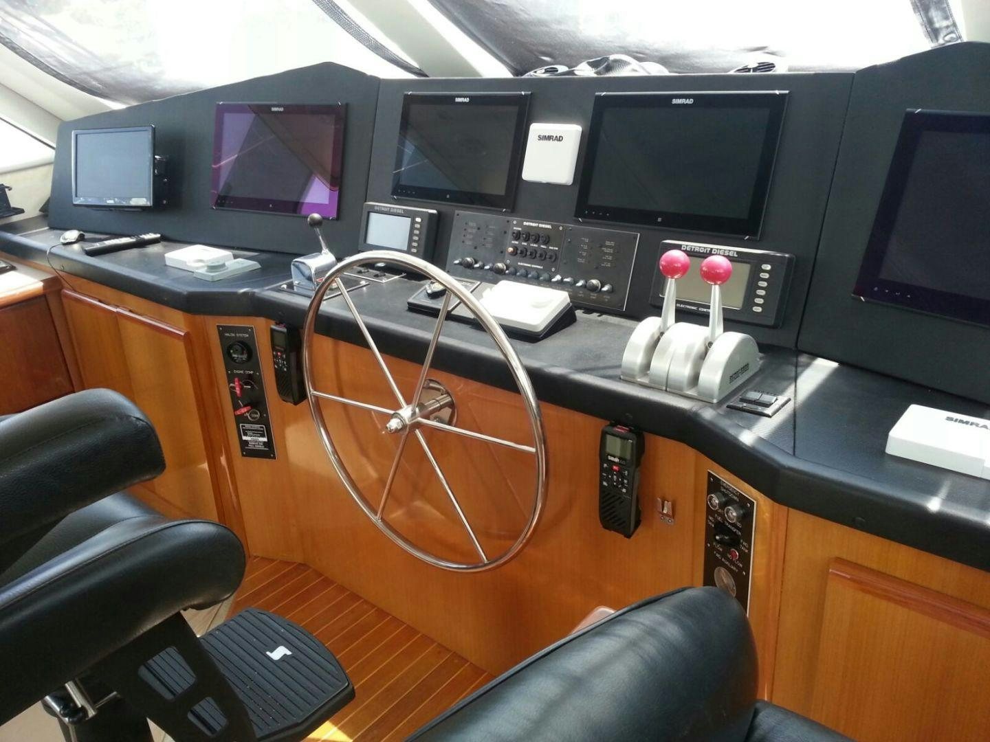a desk with computer monitors and a keyboard on it aboard BAD TO THE BONE Yacht for Sale