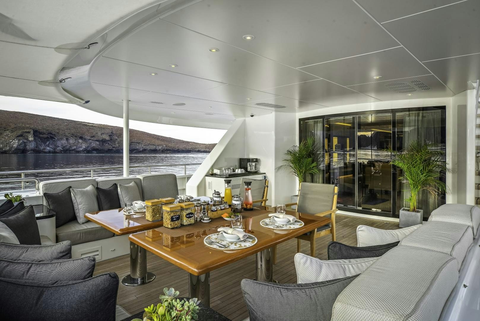 a modern living room with a large table and chairs aboard ODYSSEA Yacht for Charter