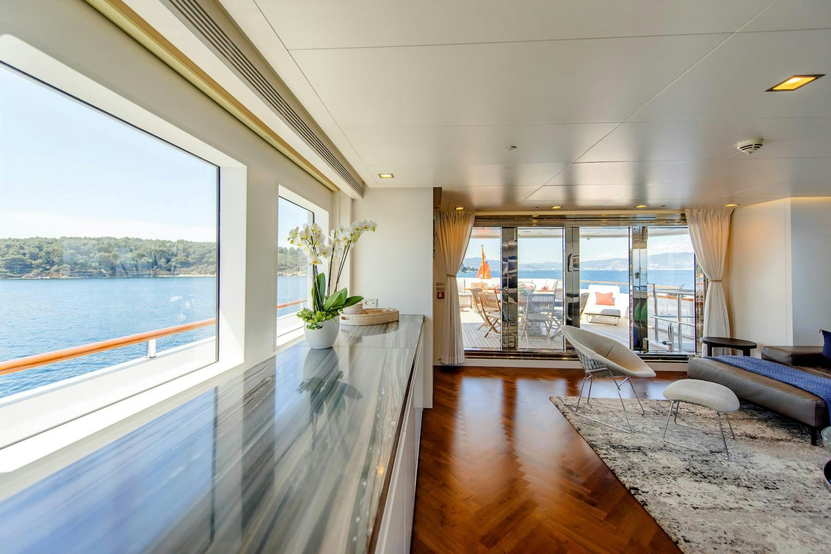 a room with a large window and a wood floor aboard OCEAN'S SEVEN Yacht for Sale