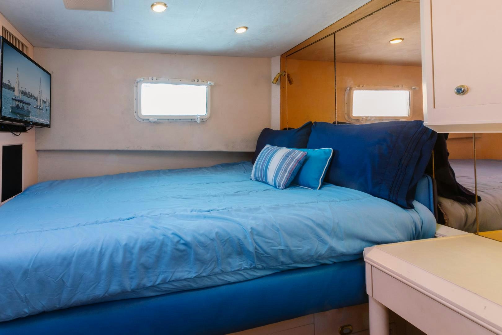 a bed with blue sheets aboard LORI LYNN Yacht for Sale