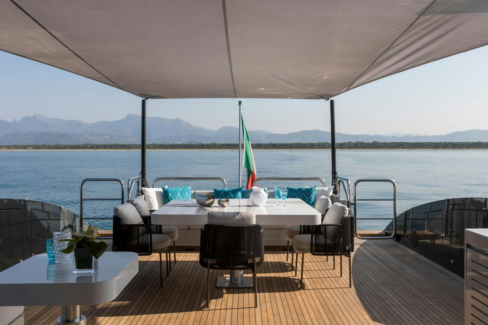 a table with chairs on it next to a body of water aboard NANA I Yacht for Sale