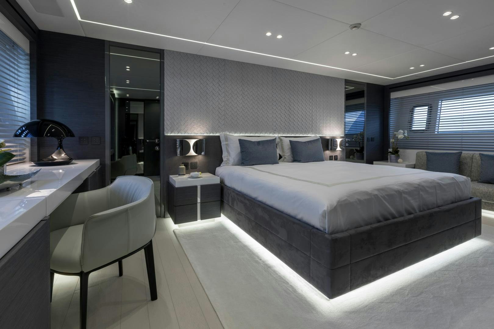 a large bedroom with a bed and desk aboard NANA I Yacht for Sale